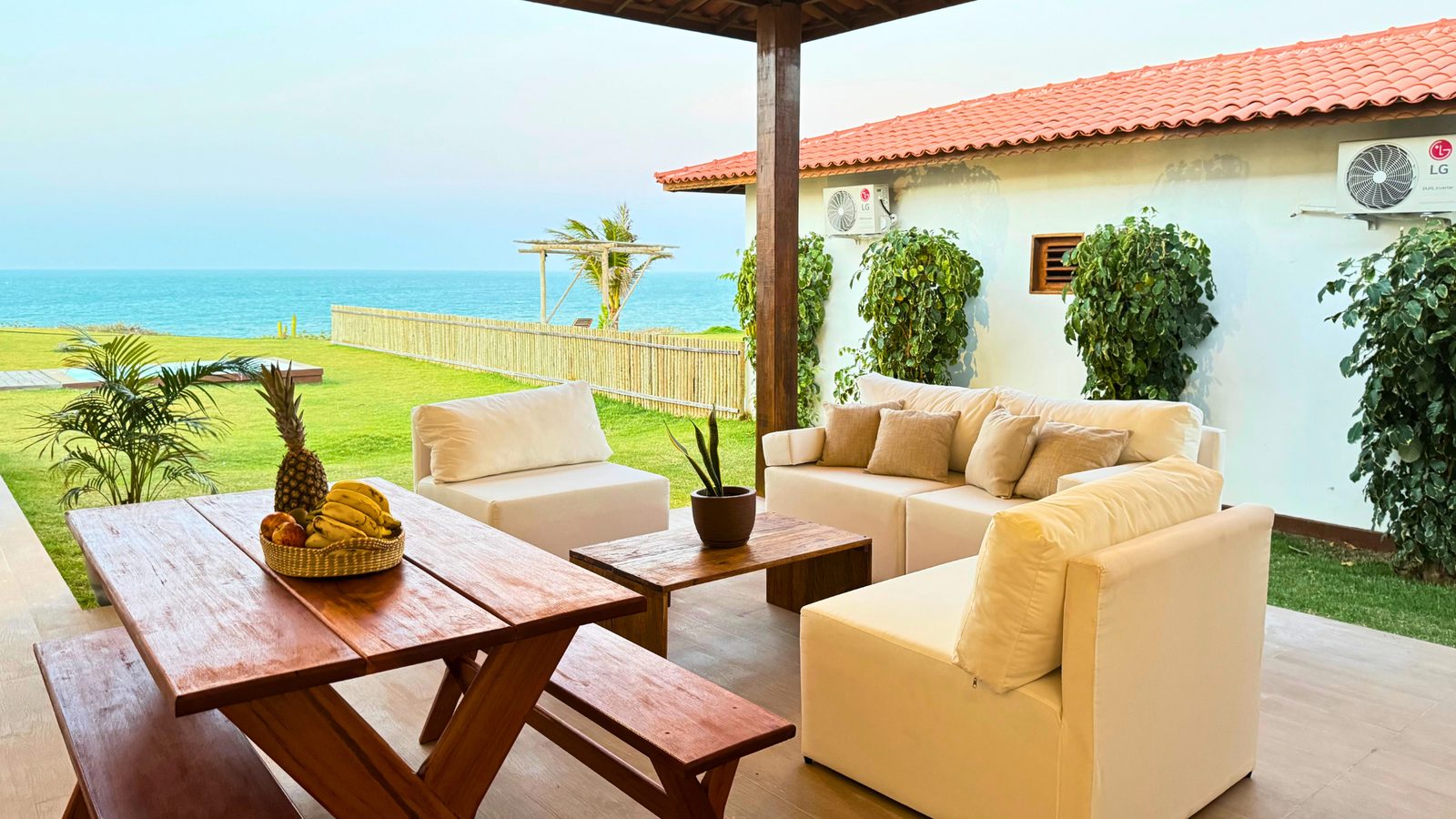 Varanda da Lar Tropical com sofás e vista para o mar