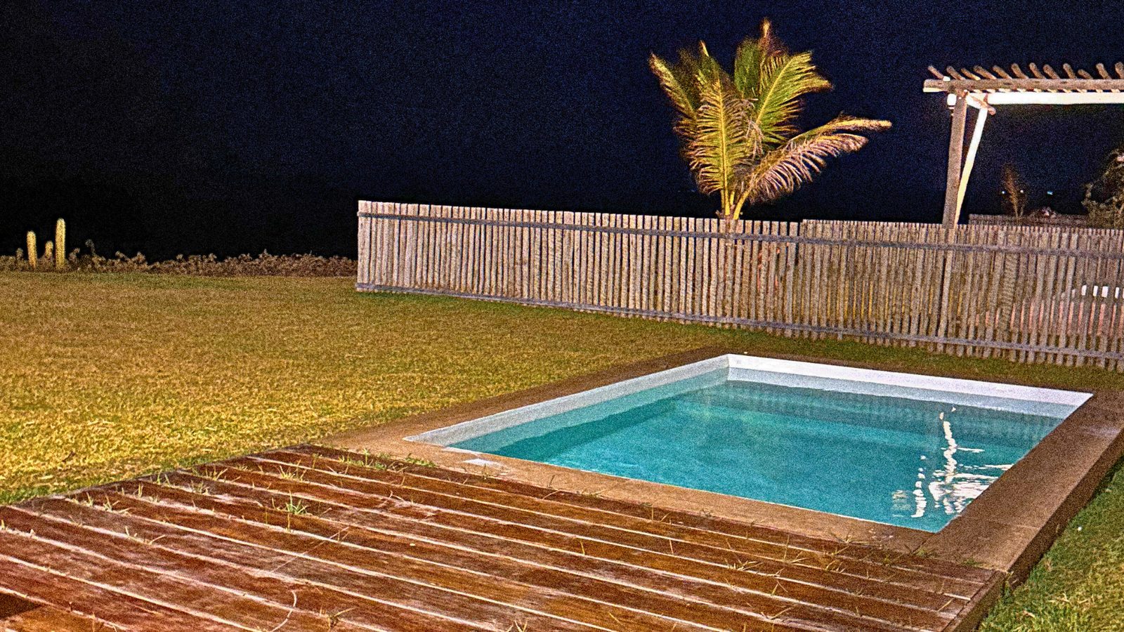 Piscina com deck de madeira ao entardecer